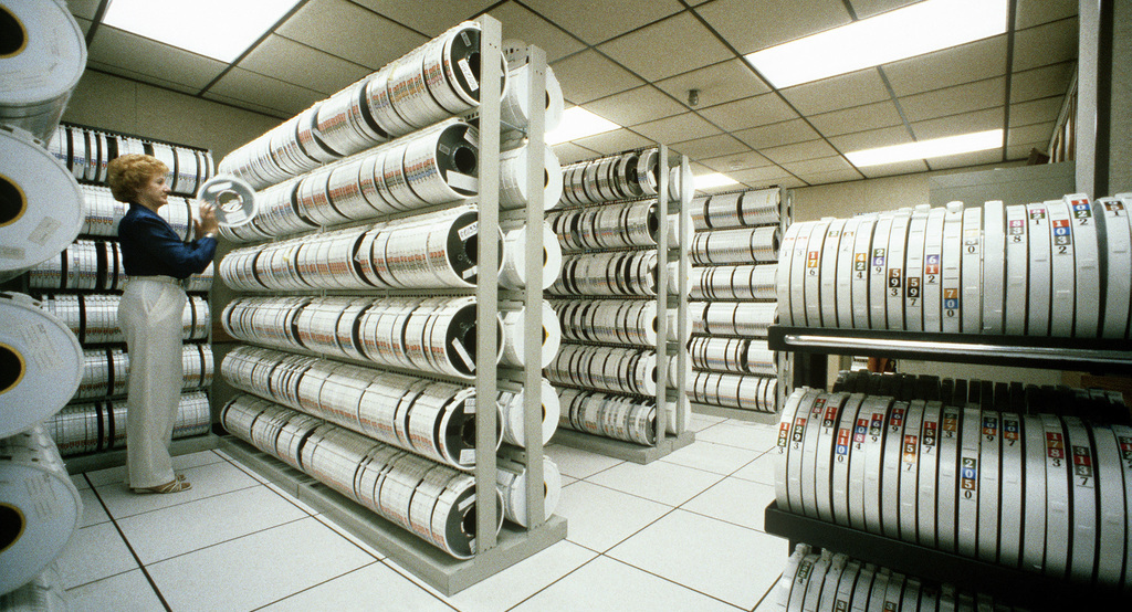 A computer operator changing backup tapes, mid-1980s