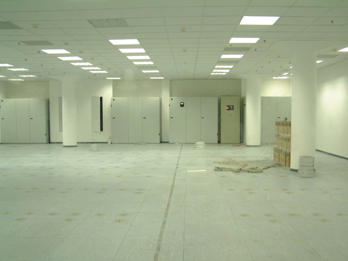 Large computer room, empty, awaiting fit out. There are cardboard boxes of cables stacked up behind a pillar.