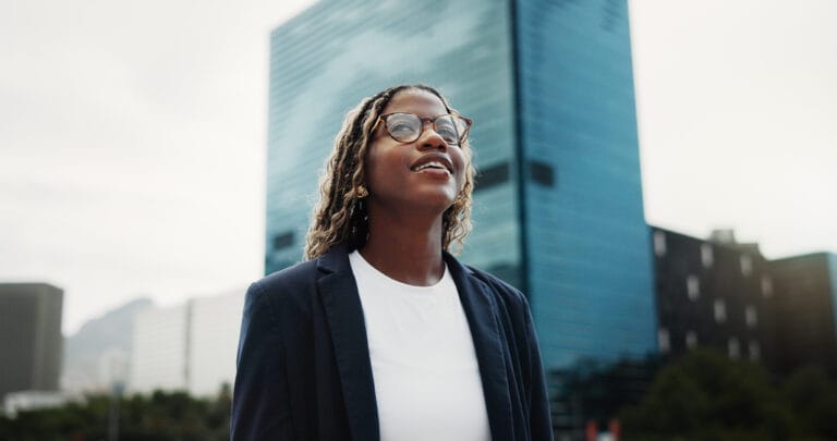 Thinking, real estate and black woman in city, smile and vision for investment opportunity. Low angle, employee or African person in street, insight of urban location or property evaluation or choice.