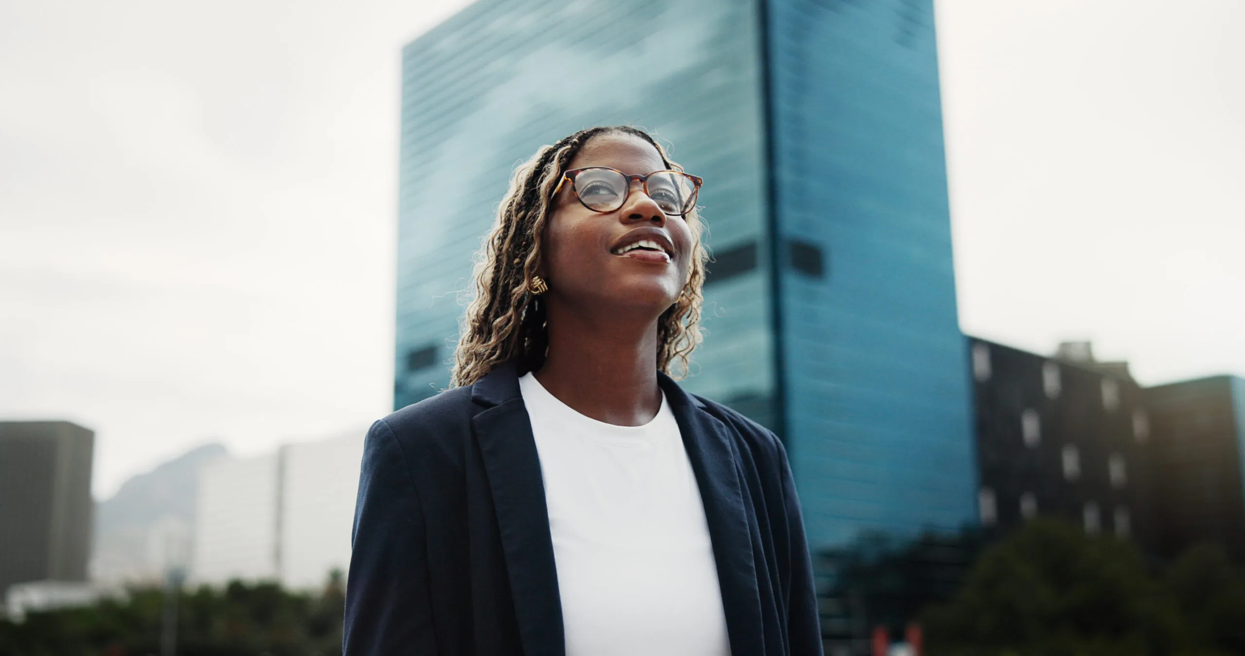 Thinking, real estate and black woman in city, smile and vision for investment opportunity. Low angle, employee or African person in street, insight of urban location or property evaluation or choice.